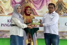 Kepala SMK Muhammadiyah 1 Cilacap dan guru menyerahkan modul projek kokurikuler disaksikan siswa berbusana adat dalam acara puncak karya.