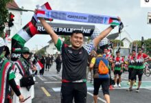 Peserta mengangkat syal bertuliskan #SavePalestine dalam ajang Run for Palestine Yogyakarta 2026 di Titik Nol Kilometer.