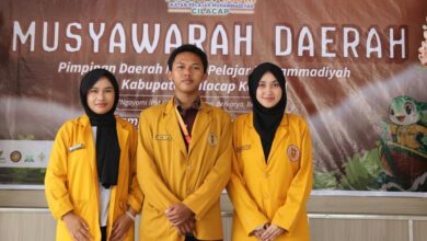 Tiga pengurus inti terpilih Musyda PD IPM Cilacap periode 2026-2028 berdiri bersama di depan latar spanduk kegiatan.
