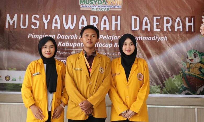 Tiga pengurus inti terpilih Musyda PD IPM Cilacap periode 2026-2028 berdiri bersama di depan latar spanduk kegiatan.