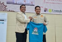 Dzulfikar Ahmad Tawalla bersalaman dan memegang kaus RAPIMWIL bersama Ketua PW Pemuda Muhammadiyah Aceh Zul Hafiyan