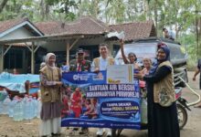 Tim Lazismu KL UMPWR dan PDM Purworejo membentangkan spanduk penyerahan bantuan air bersih bersama warga Desa Guyangan Loano.