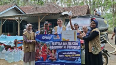 Tim Lazismu KL UMPWR dan PDM Purworejo membentangkan spanduk penyerahan bantuan air bersih bersama warga Desa Guyangan Loano.