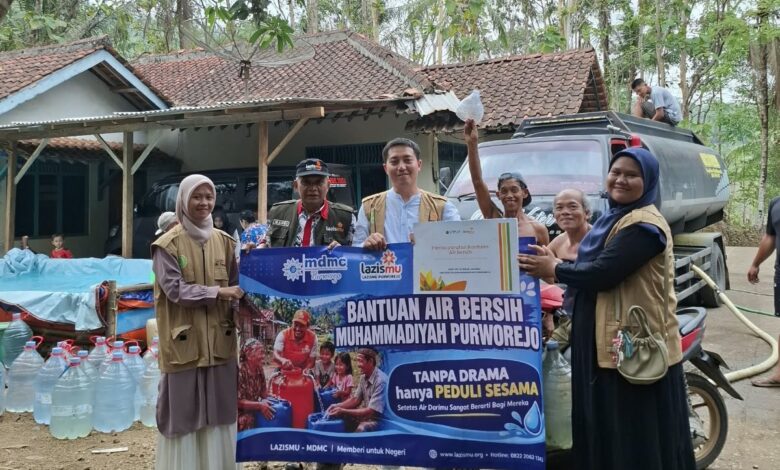 Tim Lazismu KL UMPWR dan PDM Purworejo membentangkan spanduk penyerahan bantuan air bersih bersama warga Desa Guyangan Loano.