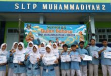Siswa pemenang lomba Semarak Bulan Bahasa 2026 SMP Muhammadiyah 2 Kroya memegang sertifikat penghargaan di depan spanduk kegiatan.