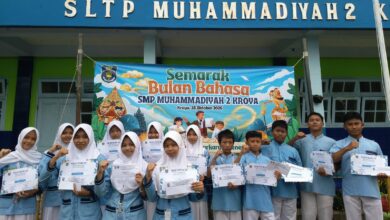Siswa pemenang lomba Semarak Bulan Bahasa 2026 SMP Muhammadiyah 2 Kroya memegang sertifikat penghargaan di depan spanduk kegiatan.